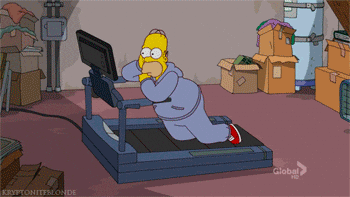 Homer Simpson lies face down on a treadmill struggling to keep up as it runs, surrounded by moving boxes in a cluttered room