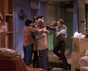 Monica, Chandler, Rachel, Joey, Ross, and Phoebe from Friends hug each other excitedly in Monica's apartment filled with moving boxes