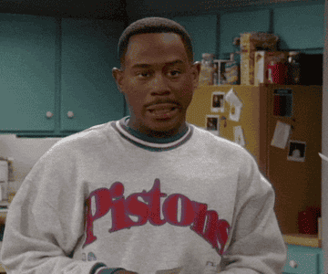 Martin Lawrence makes a funny facial expression in a &quot;Pistons&quot; sweatshirt standing in a kitchen