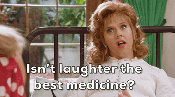 A woman with curly hair, wearing a light shirt, is sitting on a bed and looking confused. The text over the image reads, &quot;Isn't laughter the best medicine?&quot;