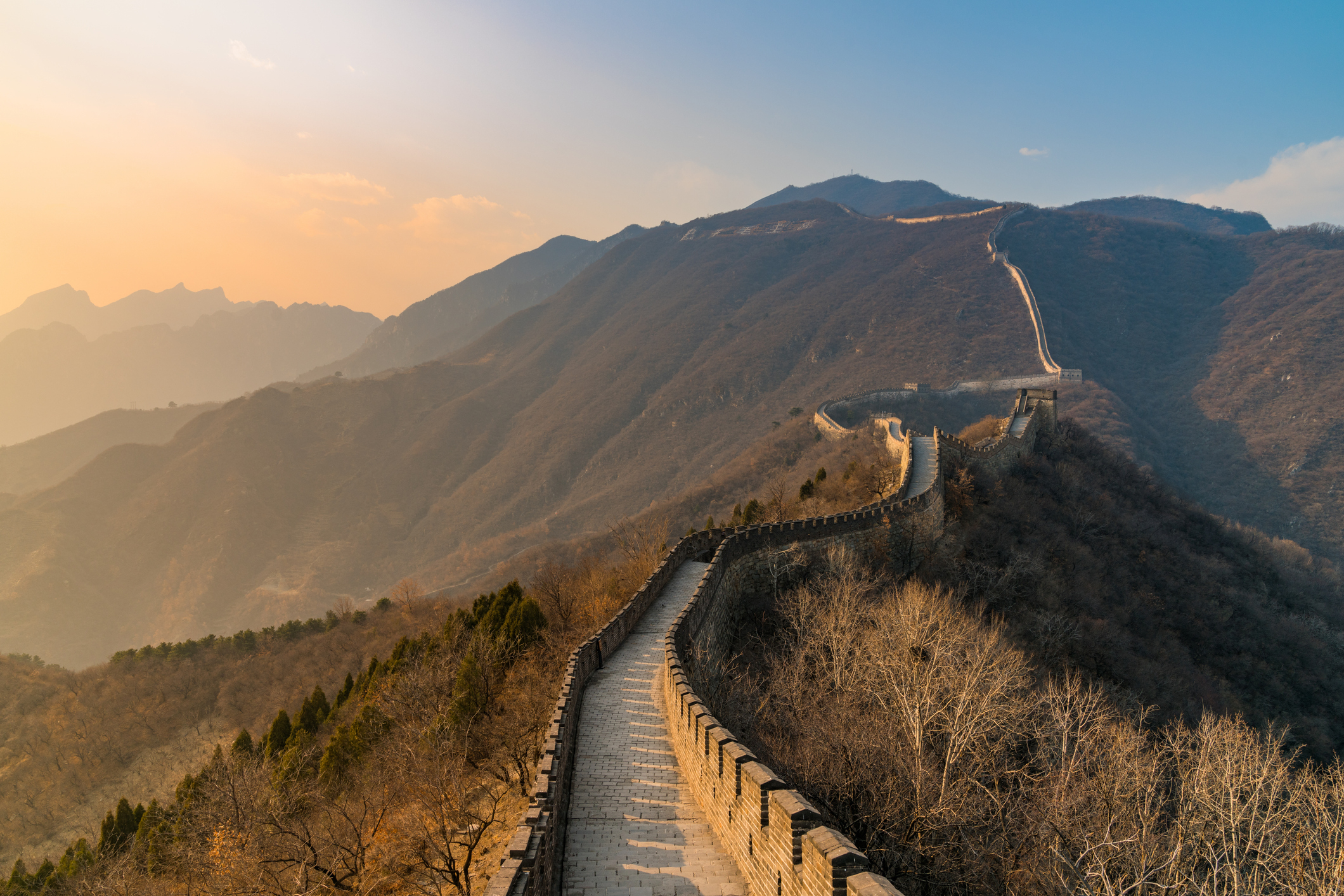 Image of the Great Wall of China stretching across mountain ridges with a scenic landscape view. No people are present in the image