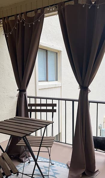 a reviewer photograph of 2 of the curtains tied backmost connected a balcony