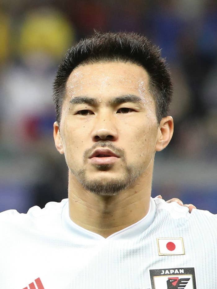 日本代表のサッカー選手、白いユニフォームを着た人の近影。