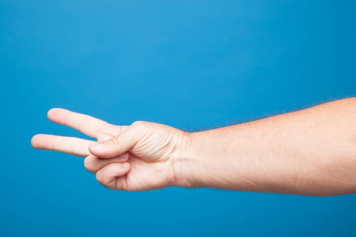 ピースサインをした右手のイメージ写真（Getty Images/iStockphoto）