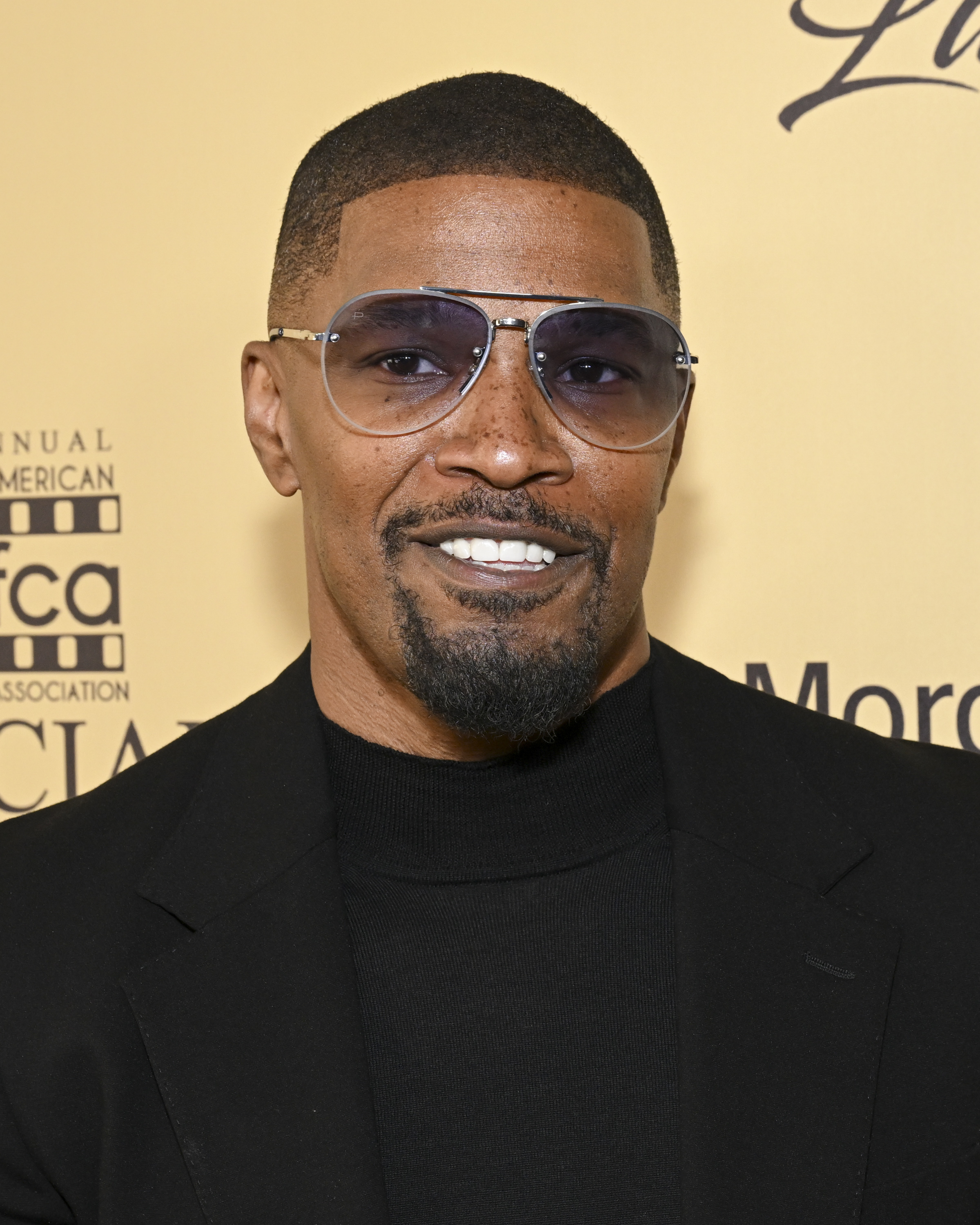 Jamie Foxx wears a black sweater and jacket