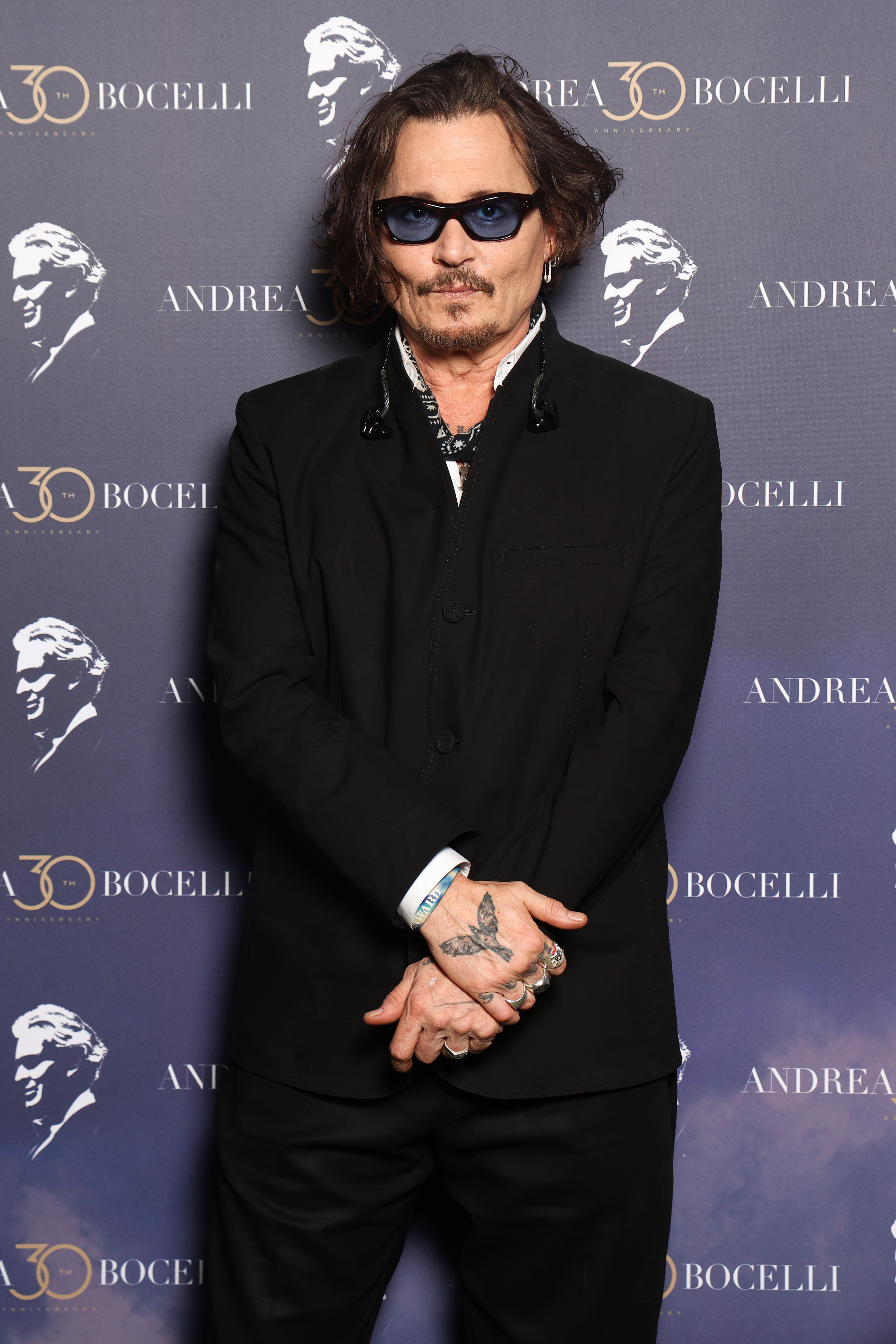 Johnny Depp wearing a black suit and sunglasses