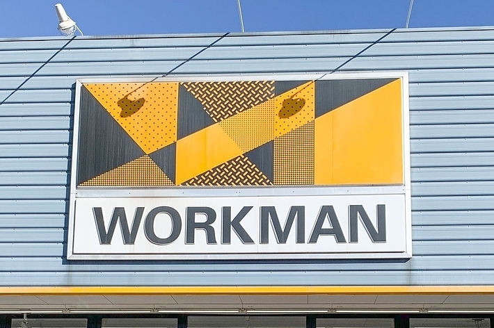 Sign for a store named &ldquo;WORKMAN&rdquo; on a building facade with geometric patterns above the text