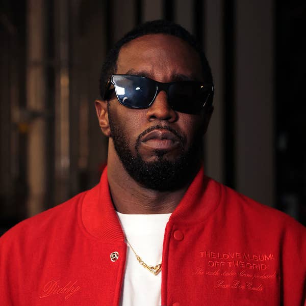 Sean &quot;Diddy&quot; Combs in a red jacket with &quot;The Love Album: Off the Grid&quot; embroidery, wearing dark sunglasses and a gold chain