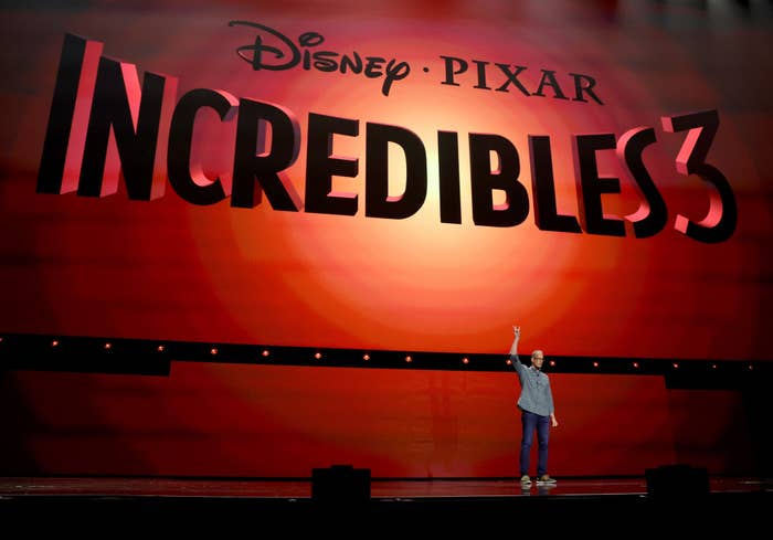 Pete Docter, standing on stage, announces &quot;Incredibles 3&quot; under a large Disney Pixar banner