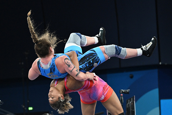 Adeline Gray and Aline Rotter-Focken in an intense wrestling match; Aline lifts Adeline off the ground