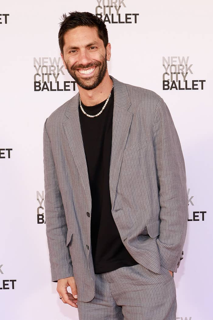 A man in a pinstripe suit poses at a New York City Ballet event