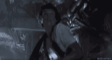 Sigourney Weaver's character, Ripley, is fighting off an alien creature in a scene from the movie "Alien."