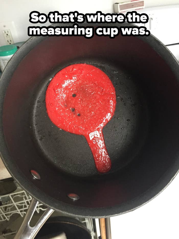A black saucepan with a solidified red spatula stuck to the bottom inside