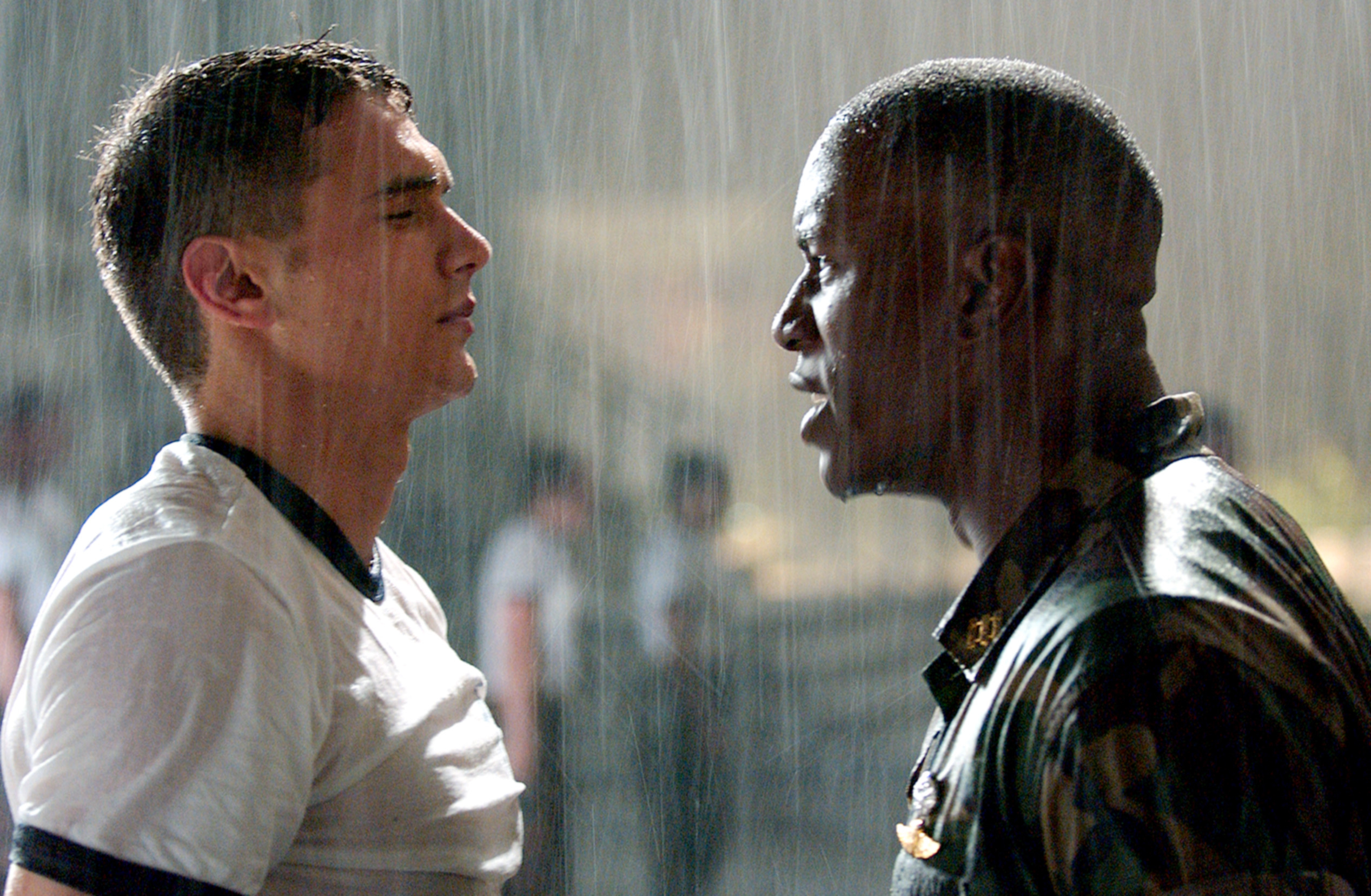 James Franco and Tyrese Gibson, standing face to face in the rain, appearing intense, from a scene in a movie