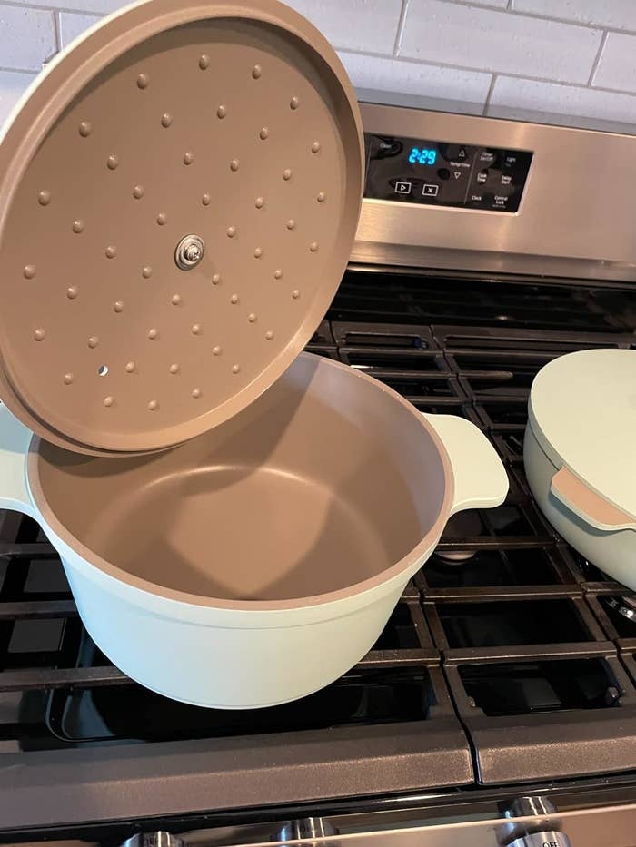 A large cooking pot with a lid is placed on a stove, with a timer on the stove indicating 2 minutes and 29 seconds