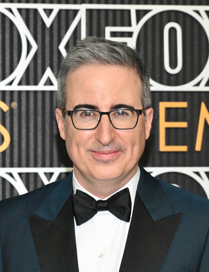 John Oliver in a tuxedo with a bow tie at the Fox Emmys event, smiling at the camera