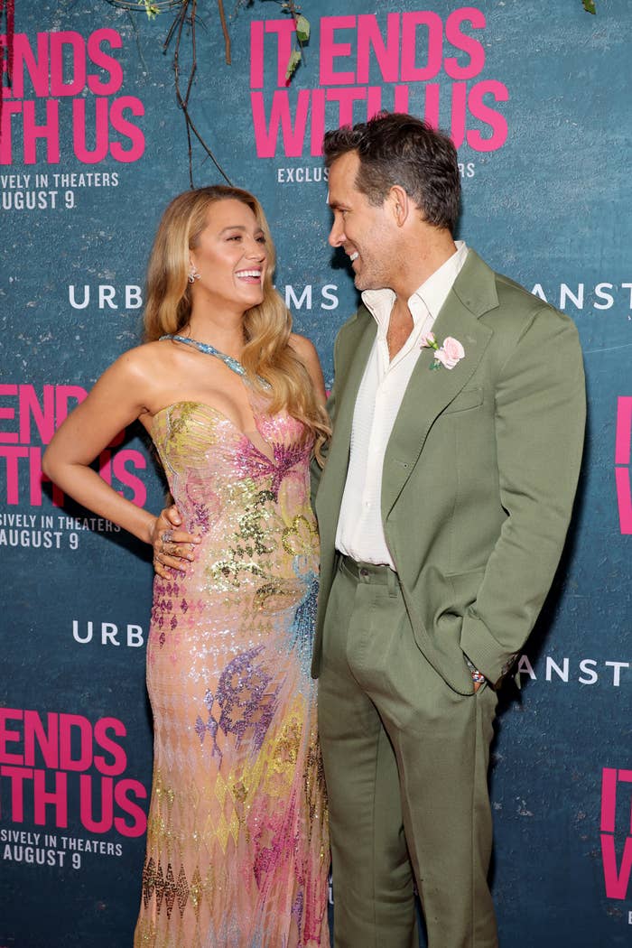Blake Lively and Ryan Reynolds at the premiere of "It Ends With Us." Blake wears a strapless, patterned dress while Ryan dons a green suit with a white shirt