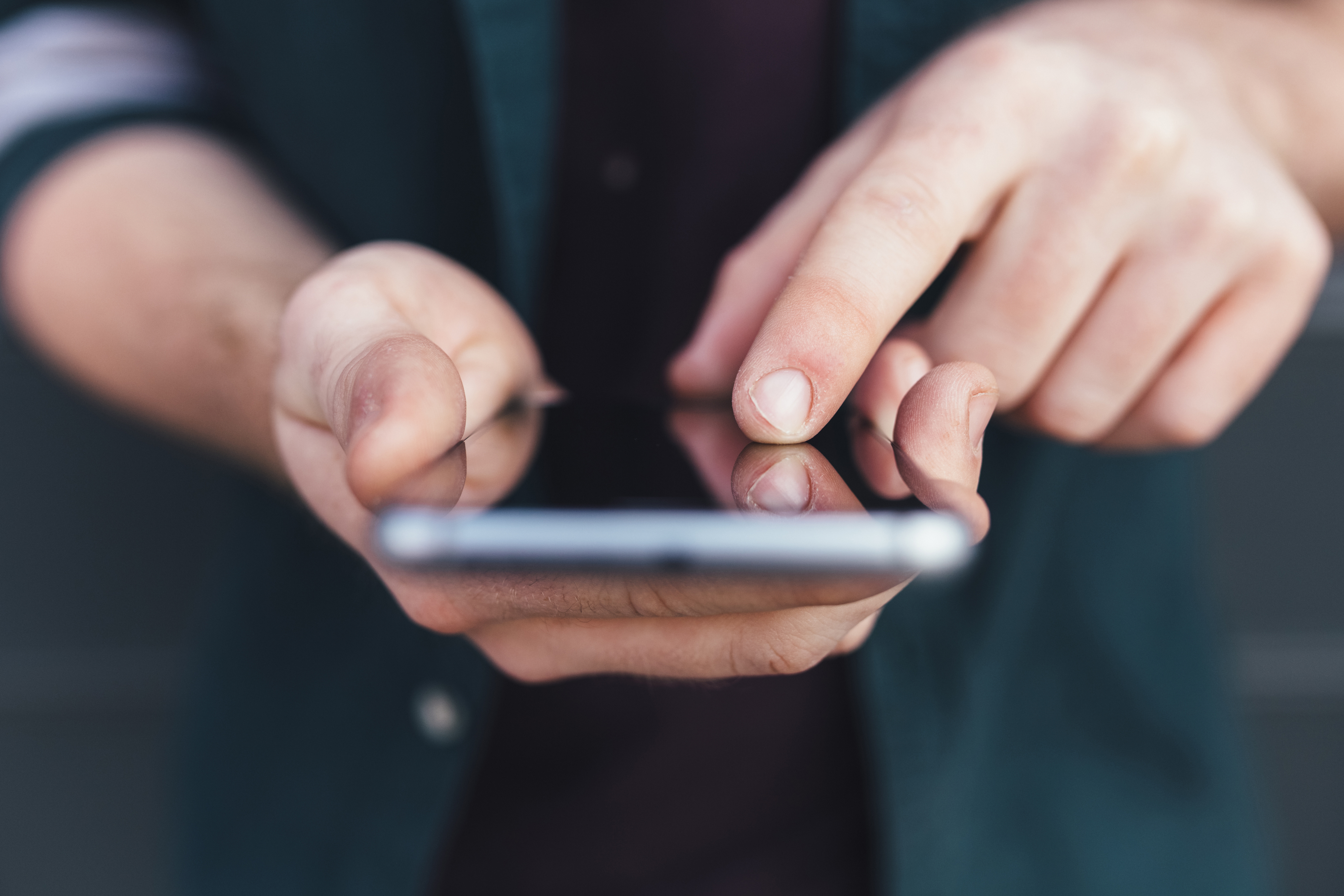 Close-up of a person using a smartphone, focusing on their hands and the device