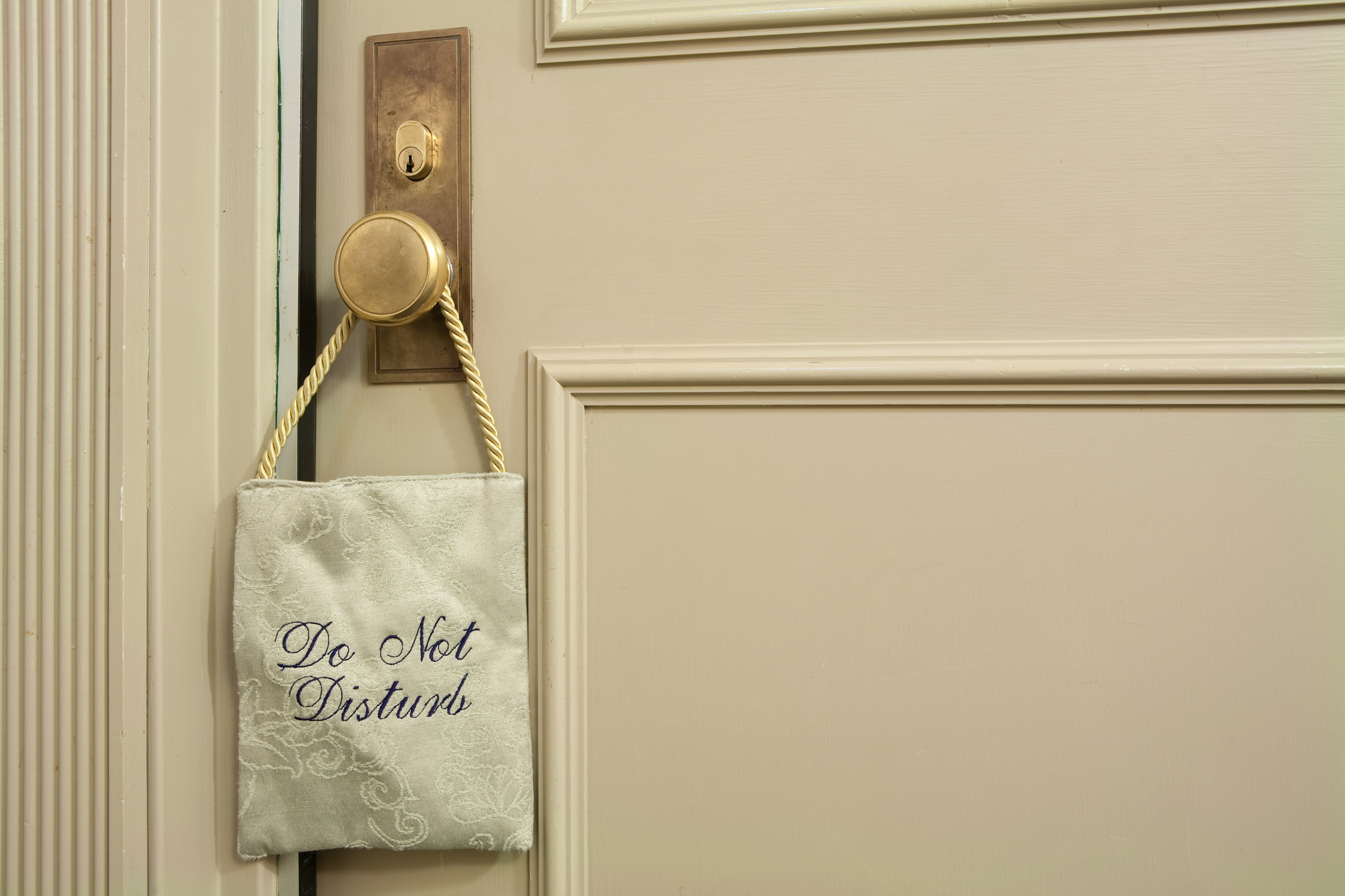 A door handle with a &quot;Do Not Disturb&quot; sign hanging from it, signifying privacy or intimacy