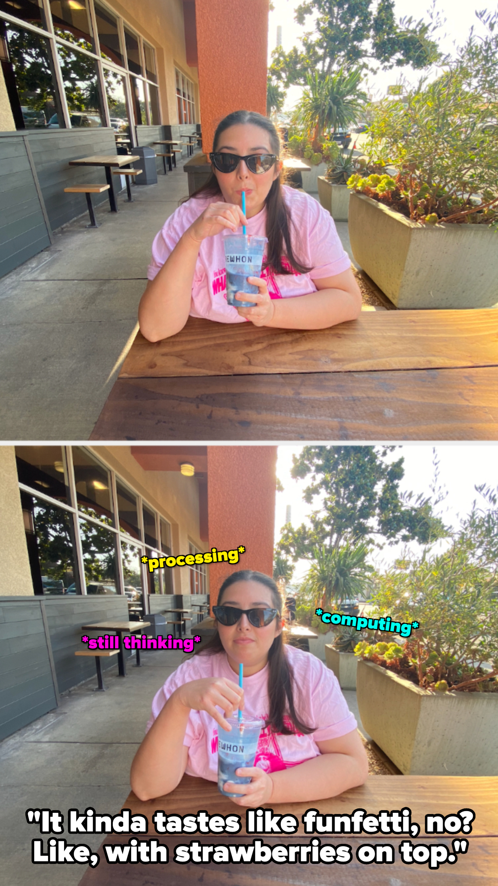Woman in sunglasses drinking from a blue beverage cup with a straw, seated outdoors at a wooden table by a restaurant patio