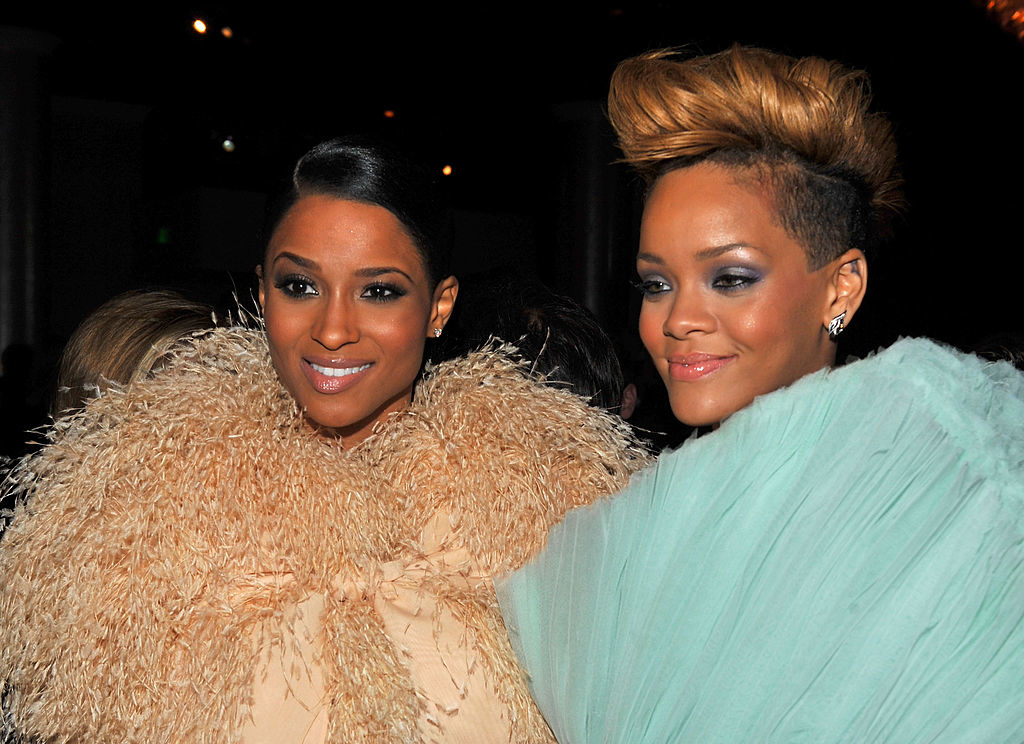 Rihanna and Ciara wearing glamorous, feathered outfits at a formal event