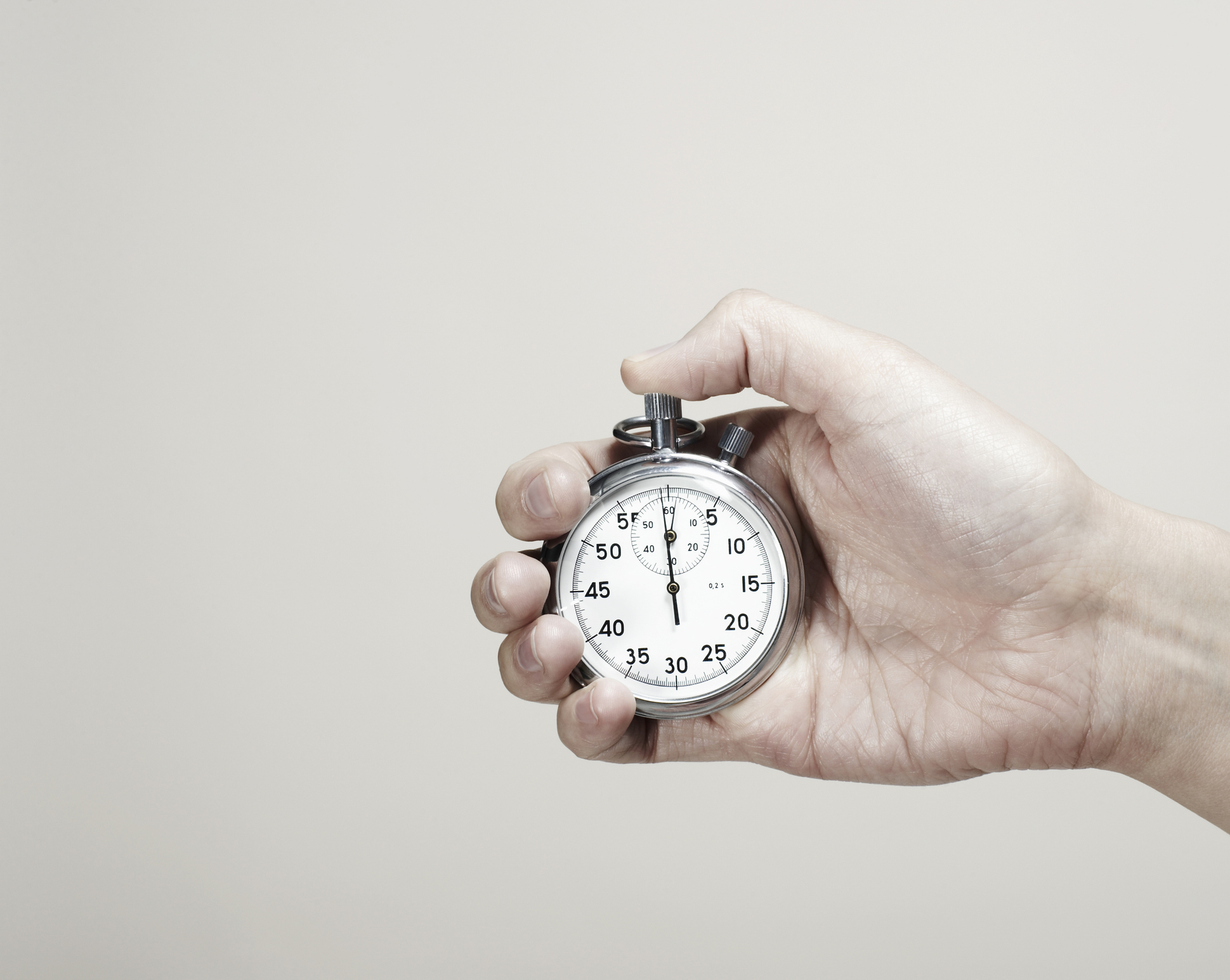 A hand holding a stopwatch displaying just under 15 seconds