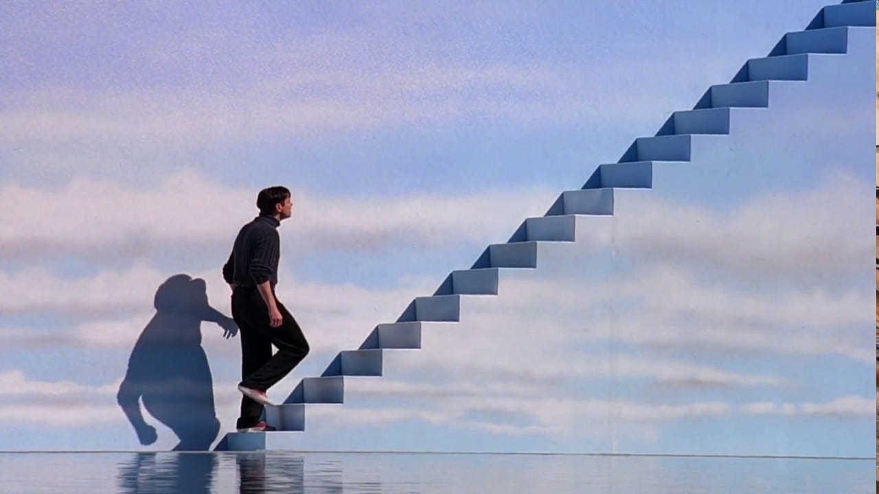 A man, portrayed by Jim Carrey, ascends a staircase that seems to lead up into the sky, symbolizing a journey or escape