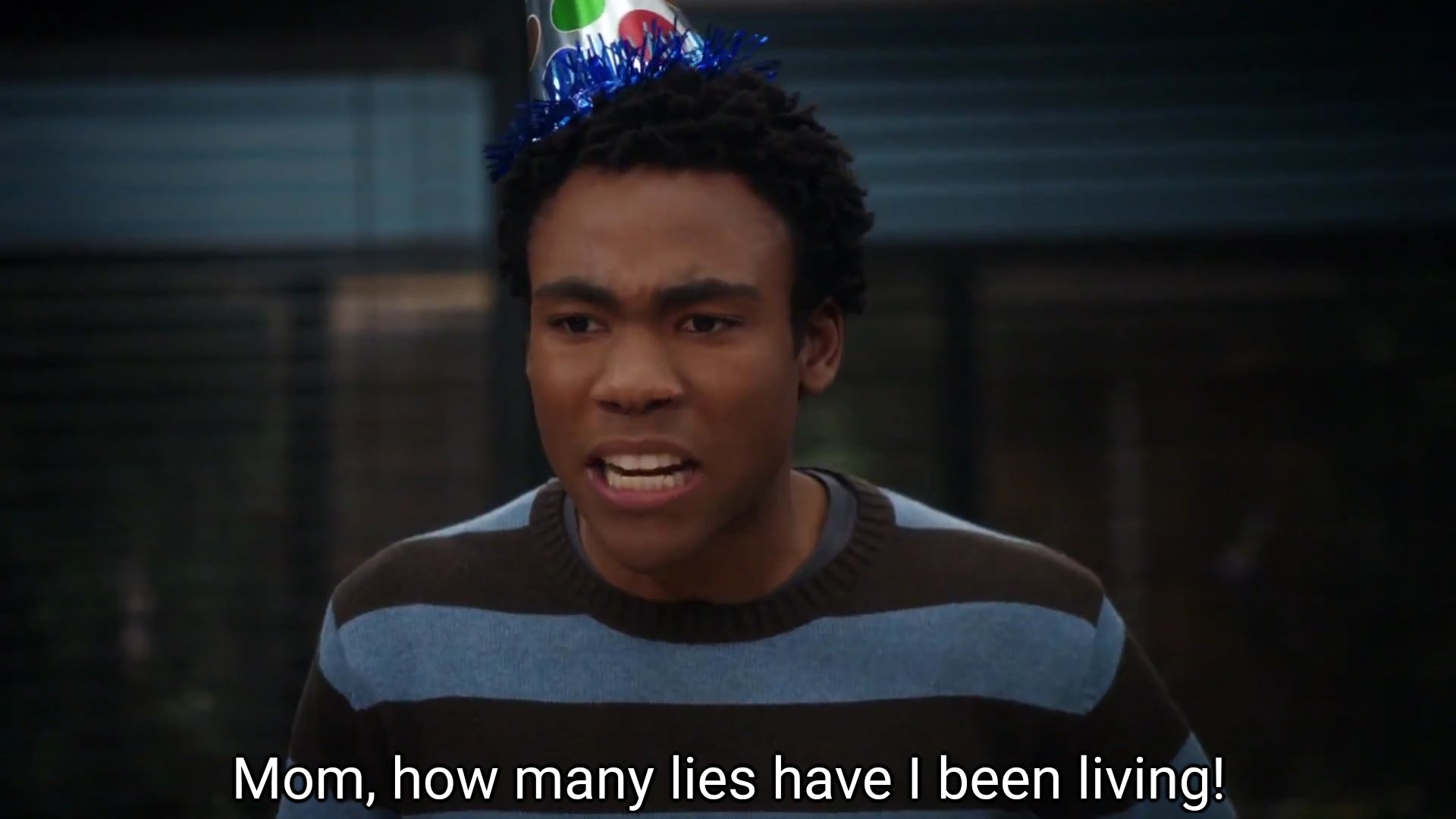 Donald Glover, wearing a party hat, looks upset and says, "Mom, how many lies have I been living!"