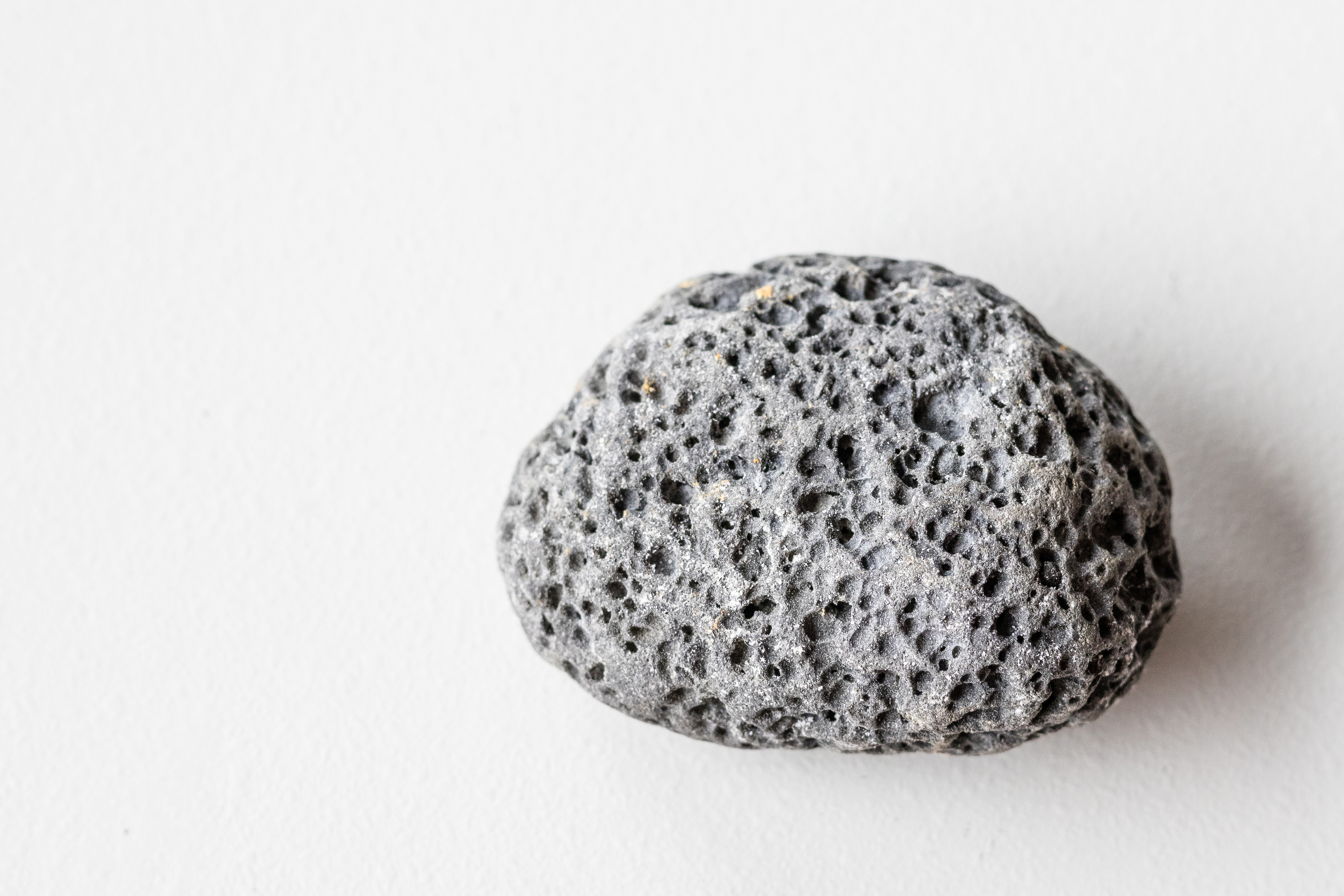 A single pumice stone sits on a flat surface