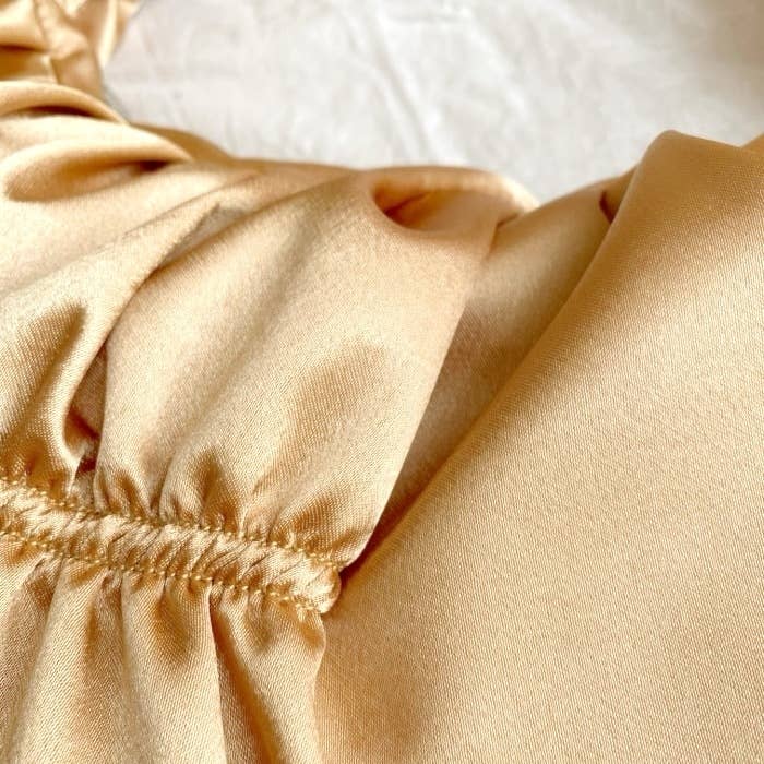 Close-up of a silky, ruched fabric with smooth, flowing texture