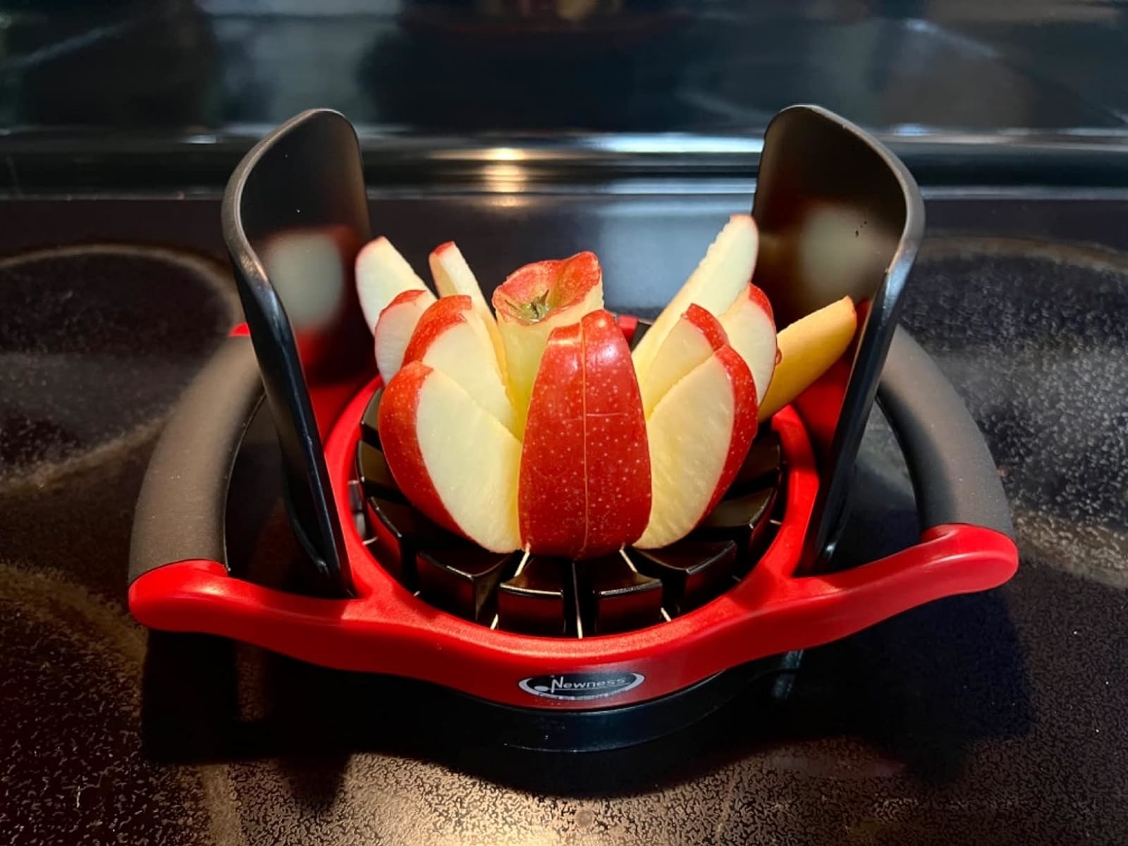 Reviewer's photo of an apple neatly sliced using an apple slicer tool with grips