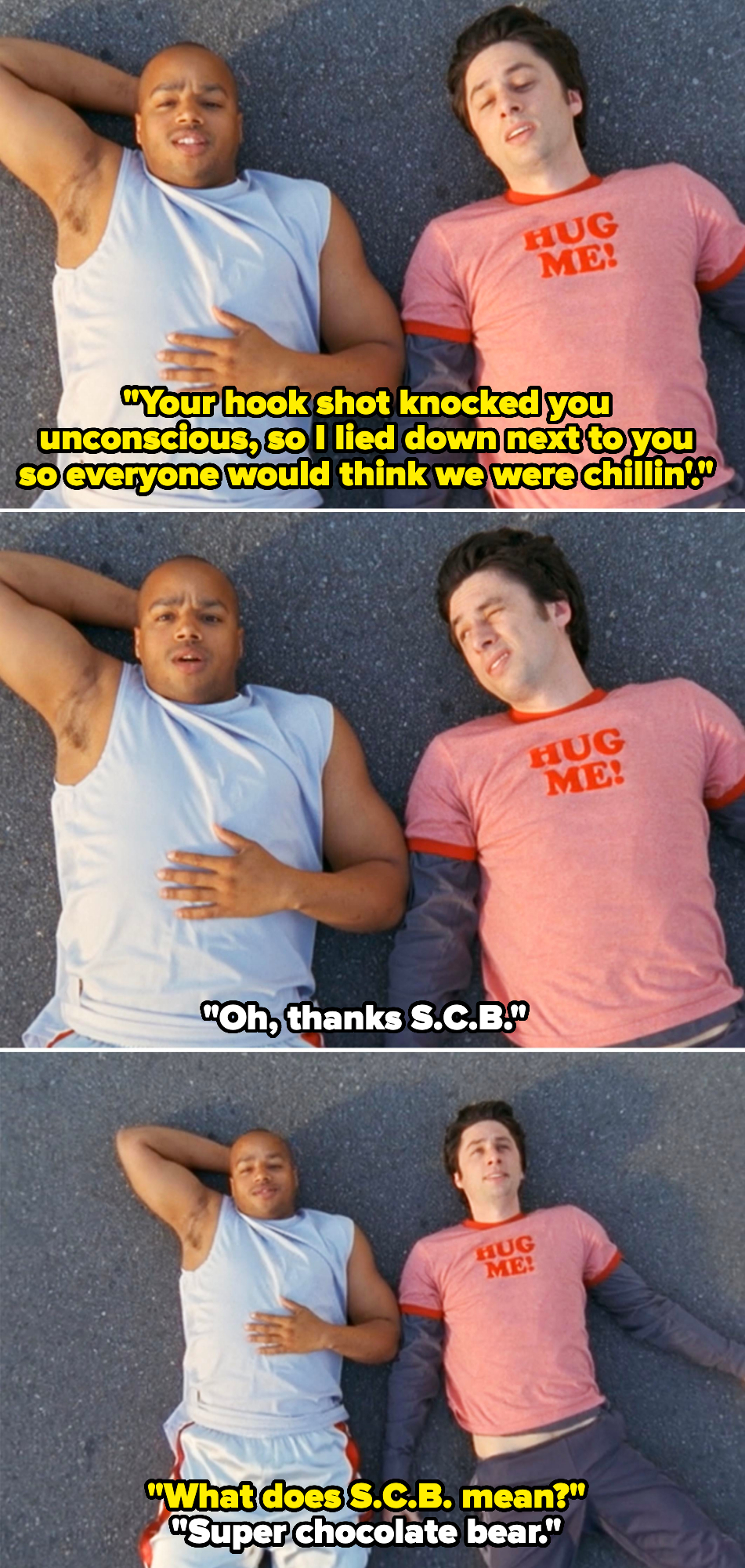 Donald Faison and Zach Braff lie on the ground in casual clothes, with Zach wearing a "Hug Me!" T-shirt