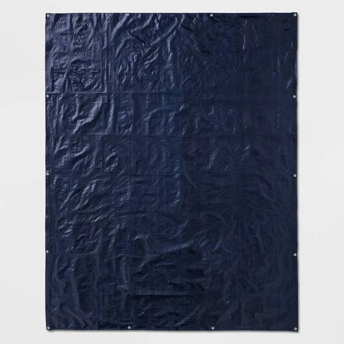 The tarp unfolded to show its 14 grommets and its navy blue color.