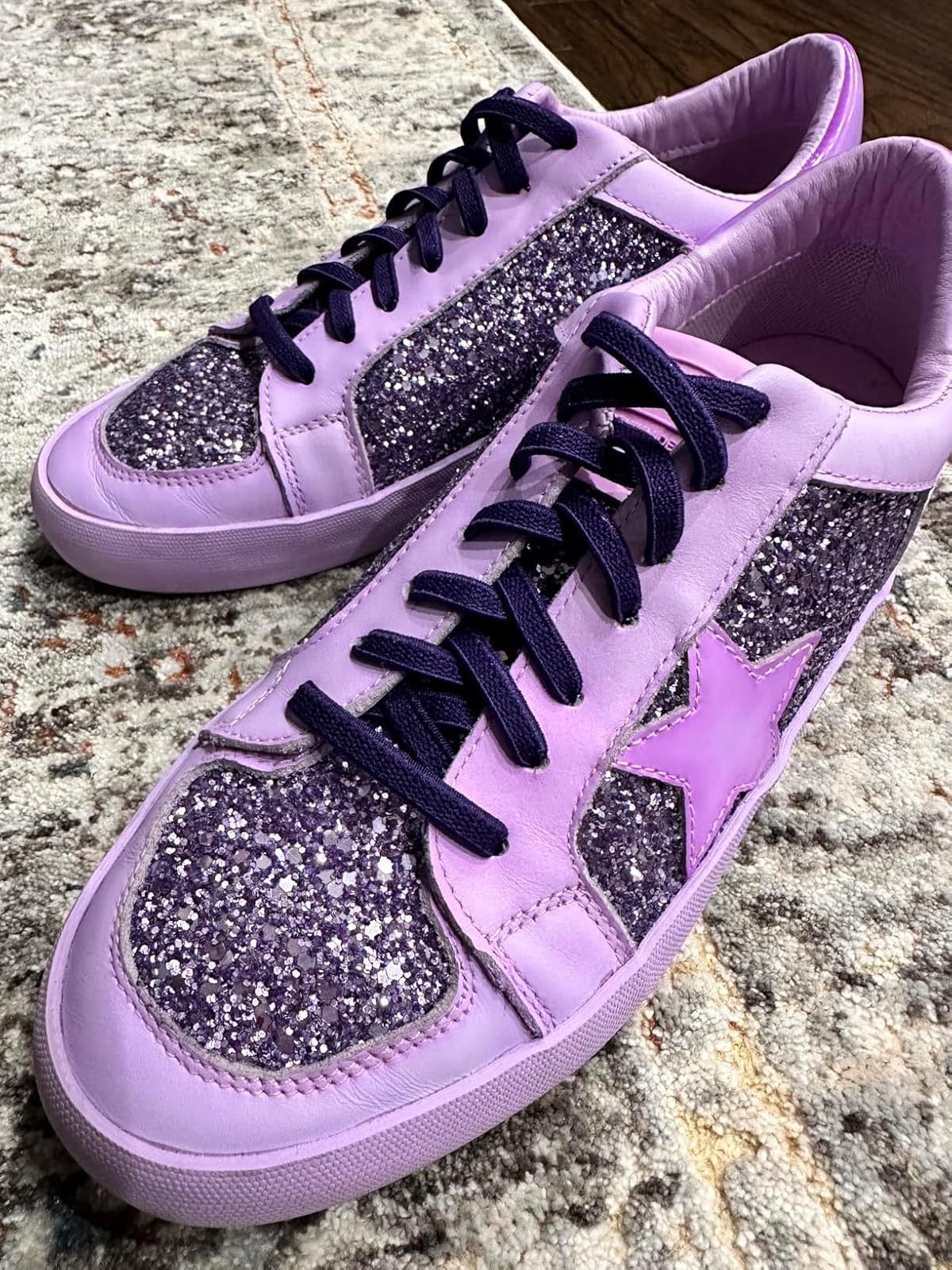 Reviewer's photo of purple sneakers with glittery sections and a star design on the side, laced with purple elastic laces