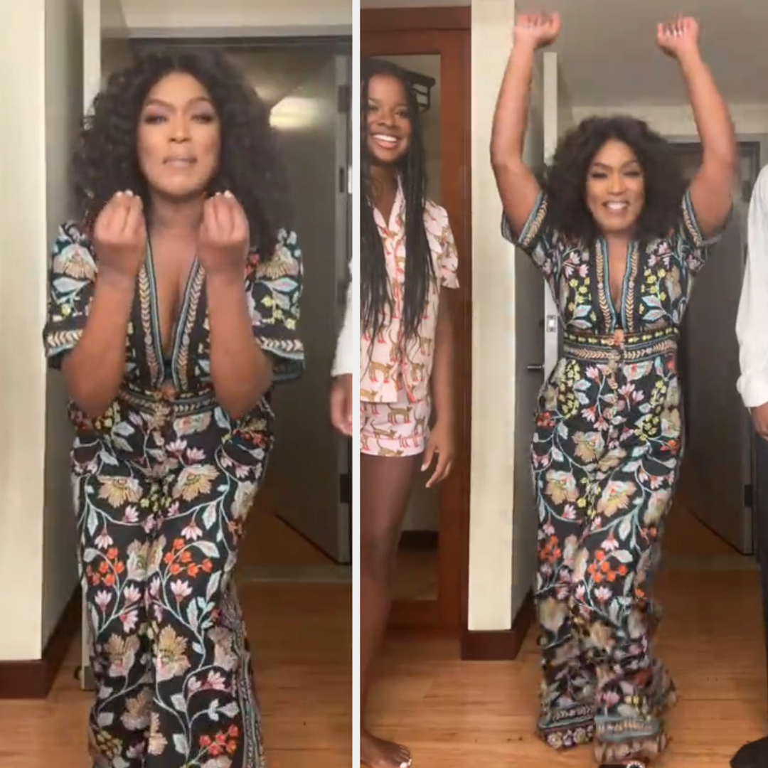Angela Bassett joyfully celebrates in a floral-patterned dress, flanked by unknown companions