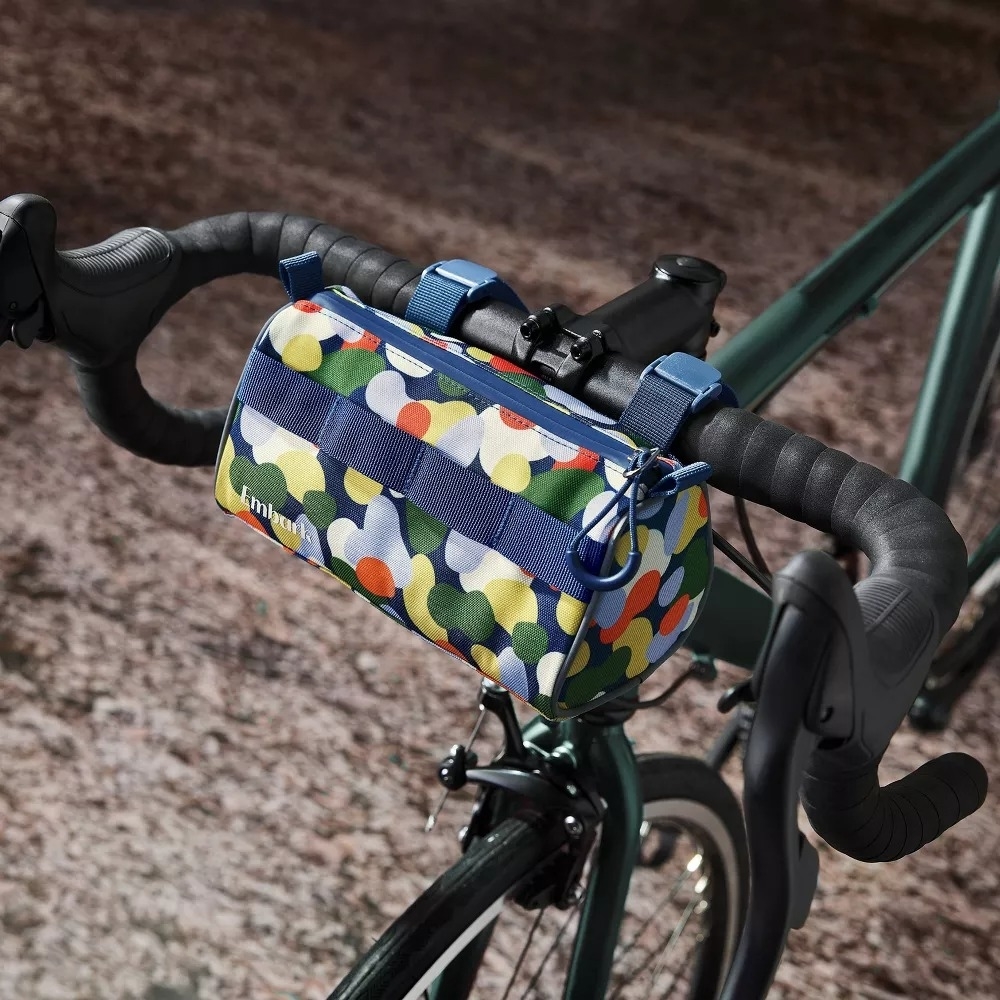 The bike bag strapped to the handlebars of a bicycle.