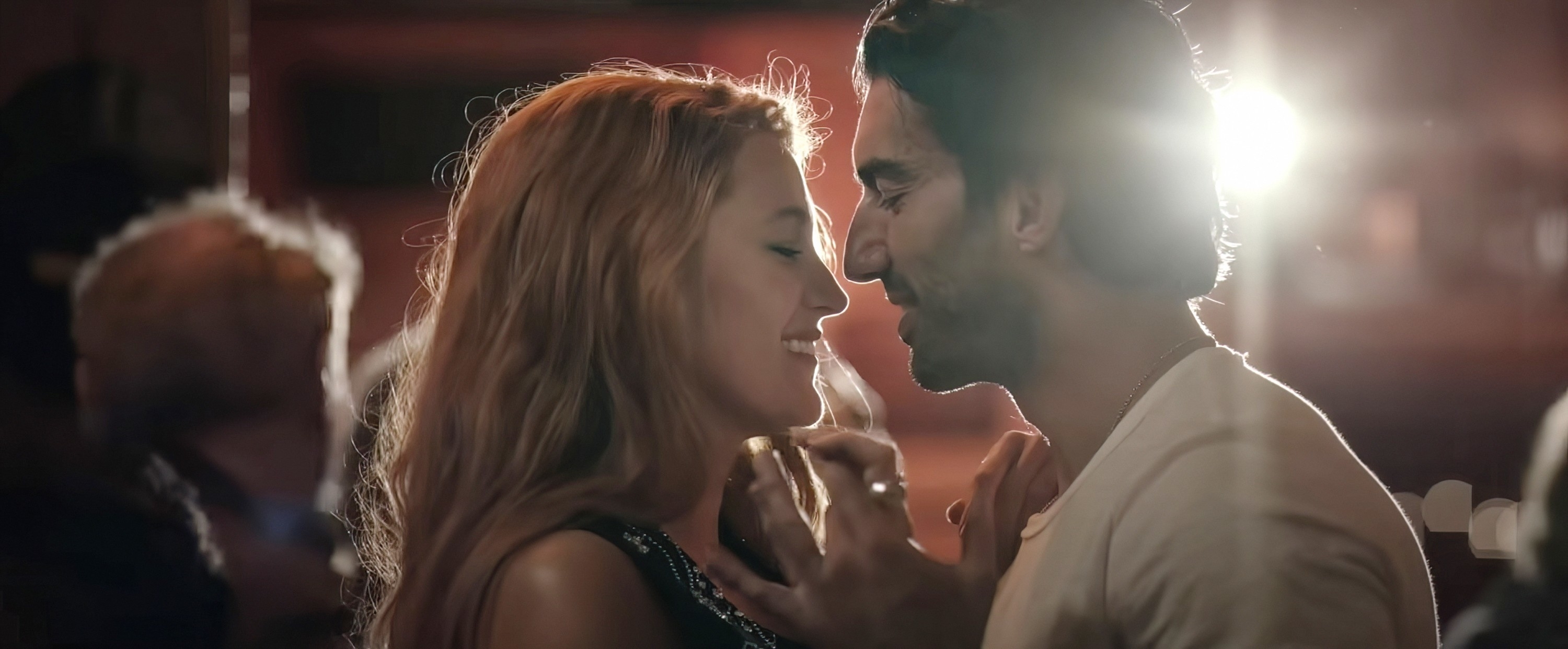 Blake Lively and Justin Baldoni smile at each other intimately in a close-up scene from a TV show or movie