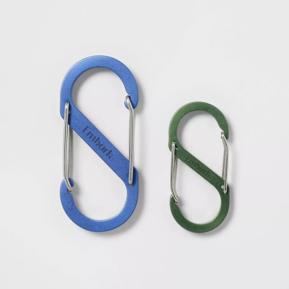 The two S-shaped carabiners, a larger blue one and a smaller green one, on a white background