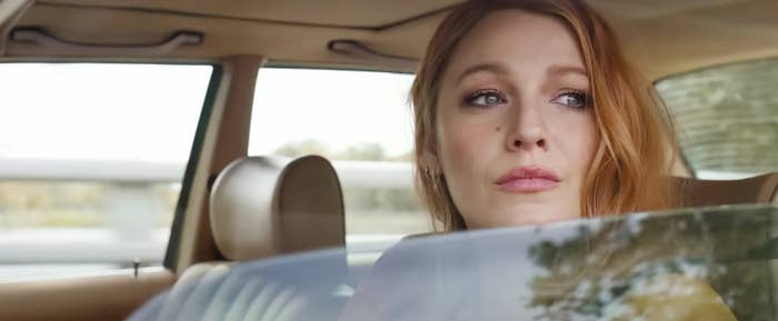 Blake Lively looks pensively out of a car window while seated in the back seat