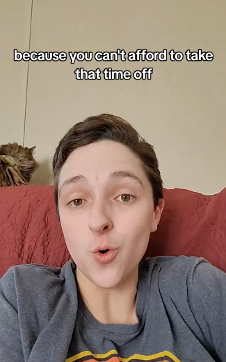 A person with short hair talking with a surprised facial expression, text above reads: "because you can't afford to take that time off." A cat is on the back of the couch
