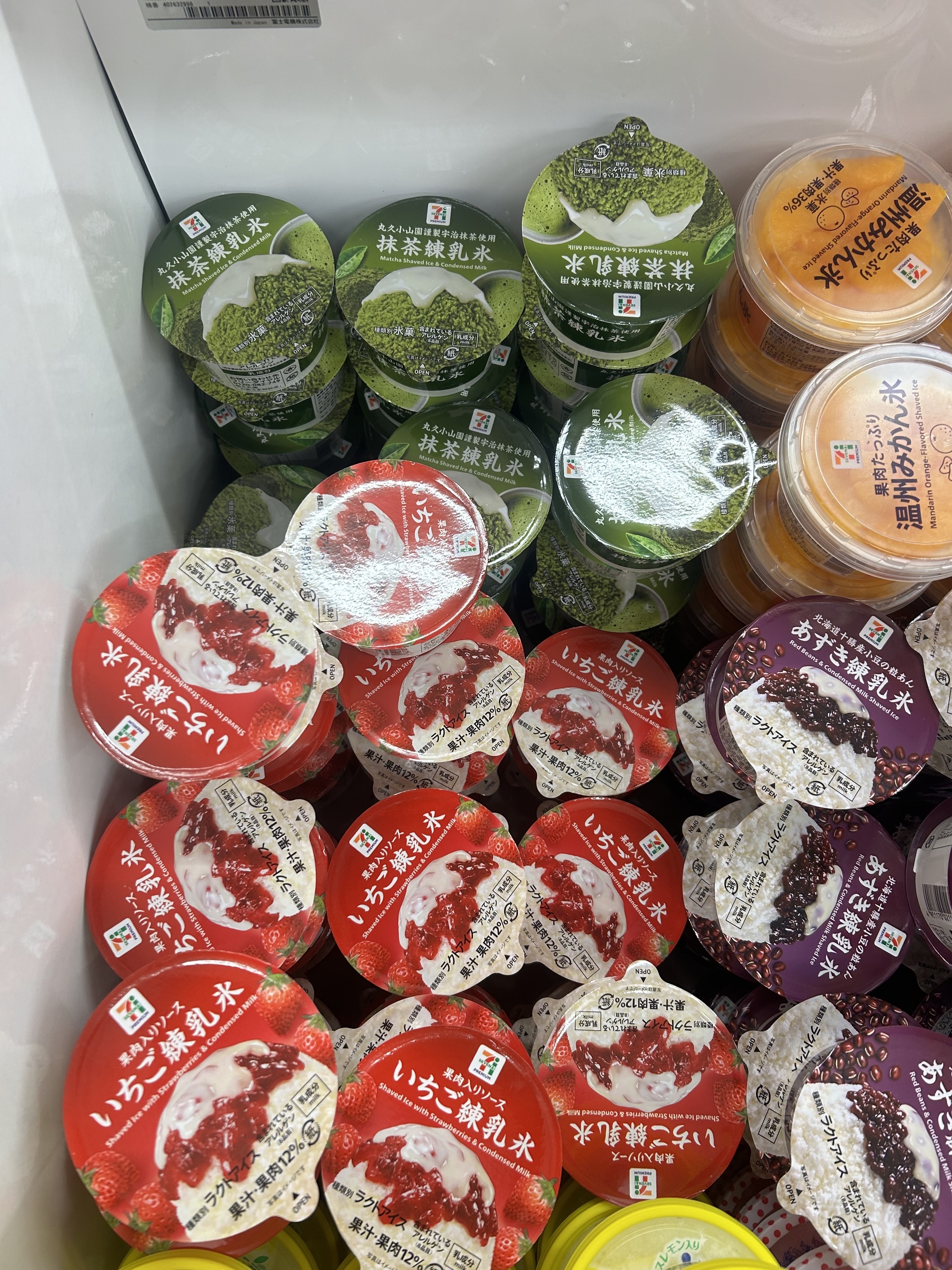 Various flavors of Japanese jelly and pudding desserts in a store display, including matcha and red bean