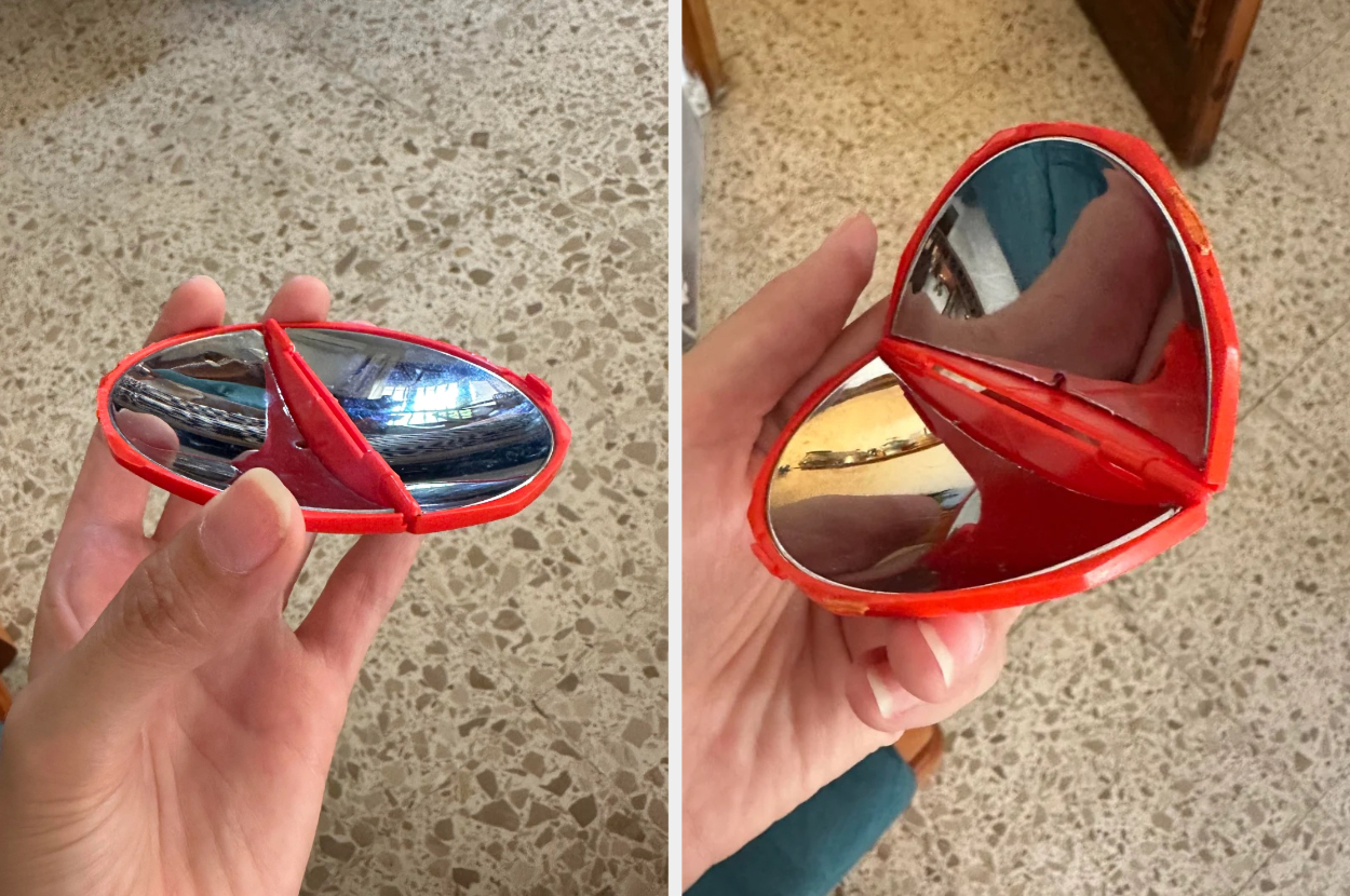 Hand holding a clamshell-shaped red accessory that opens to reveal mirrors