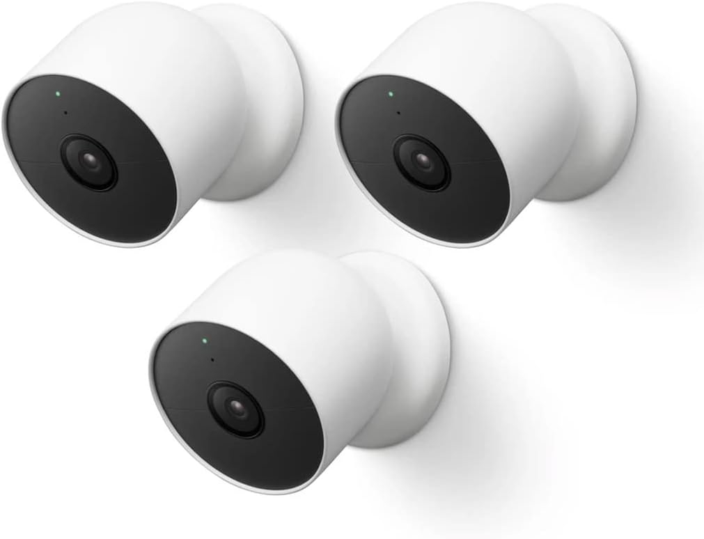 Three white and black security cameras are mounted on a wall, all pointing in different directions