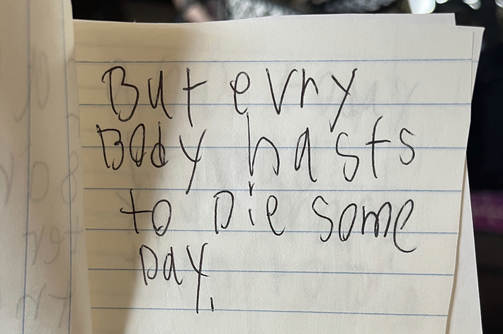 誰かによって手書きされた「But every body has to die some day」というメッセージと簡単な絵が描かれているノートのページ。