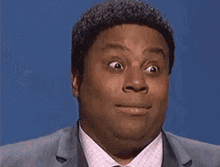 I don't know who these individuals are. A man in a suit and tie looks surprised with wide eyes and a slightly open mouth against a blue background