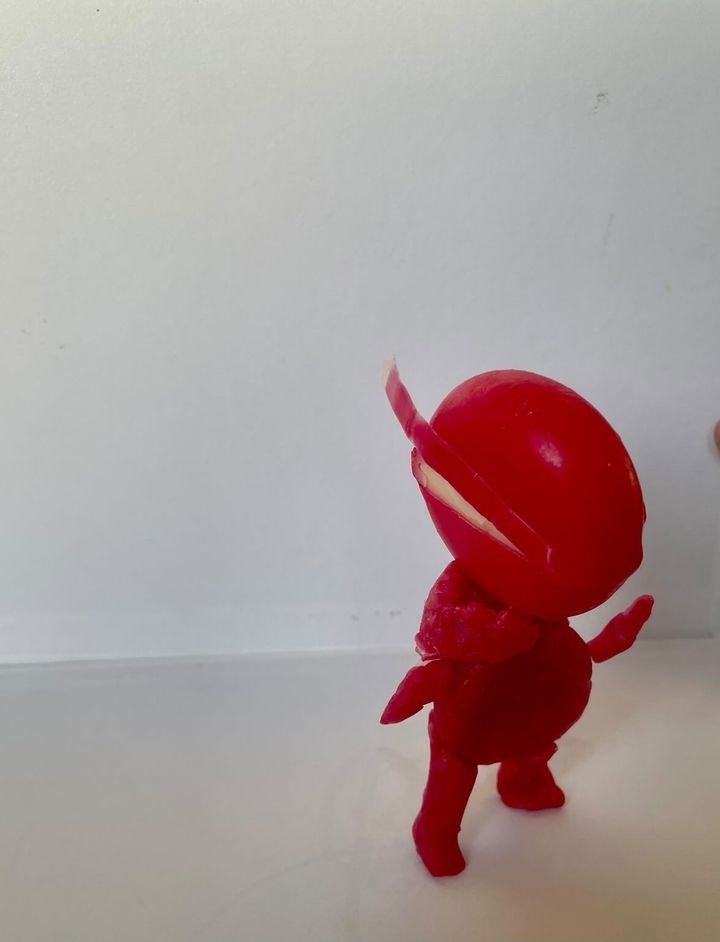 Image of a small, red figurine of an animated character. No text or celebrities are visible