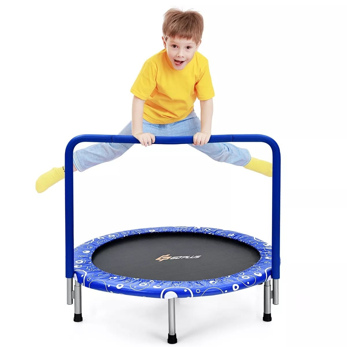 A young child wearing a yellow shirt and blue pants jumps on a small trampoline with a safety bar, displaying its use for exercise and play