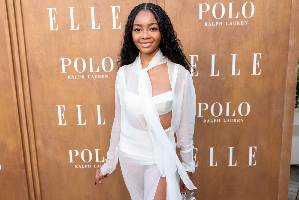 Skai Jackson in an elegant sheer wrap dress at an event with Polo Ralph Lauren and Elle branding on the backdrop