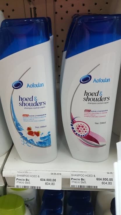 Two bottles of "AoFoulan Head & Shoulders" shampoo on a store shelf, priced at 604.80 Bs