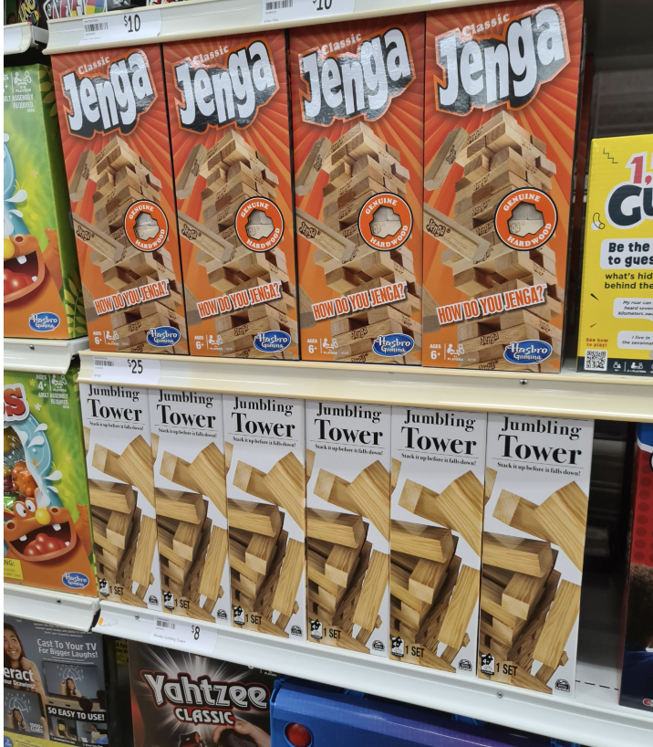 Jenga and Jumbling Tower games on store shelves, positioned beside Candyland and Yahtzee Classic games